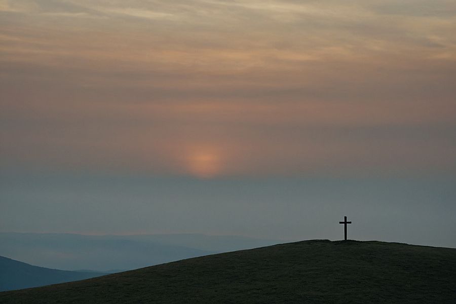 Поклонный крест на холме в тумане на рассвете